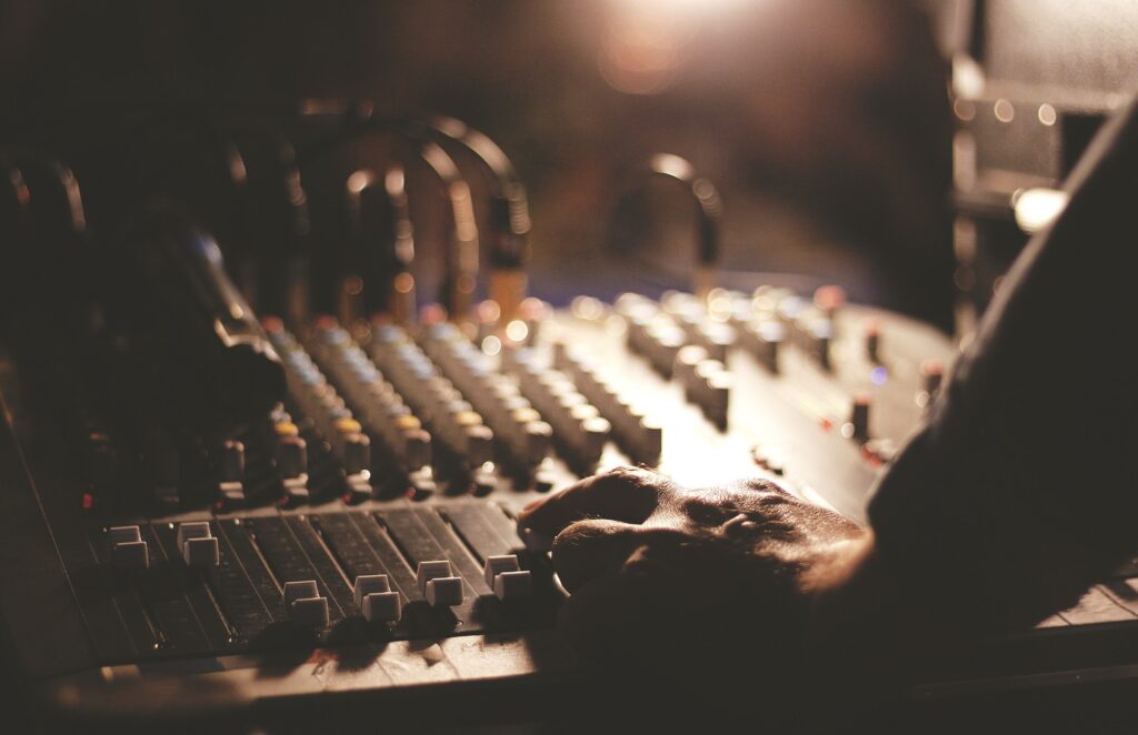 Hands on a sound mixing console. Details of sound engineer room.